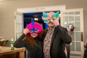 two people holding party masks